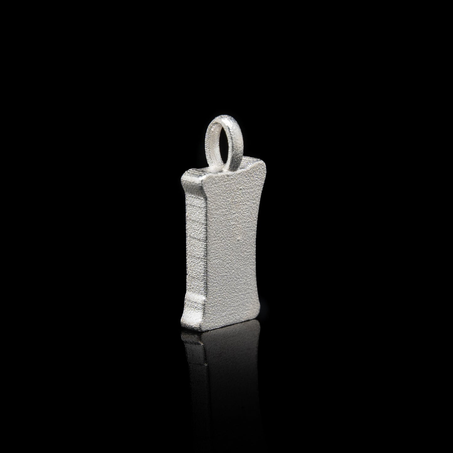 Back of everyman sterling silver smile head charm pendant with a unique design on a black background
