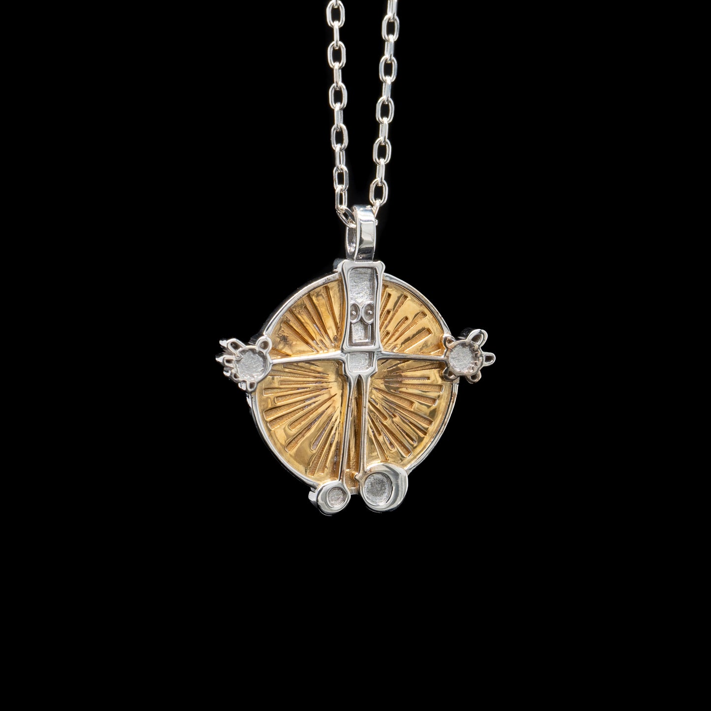 Gold and silver circular pendant necklace on a black background