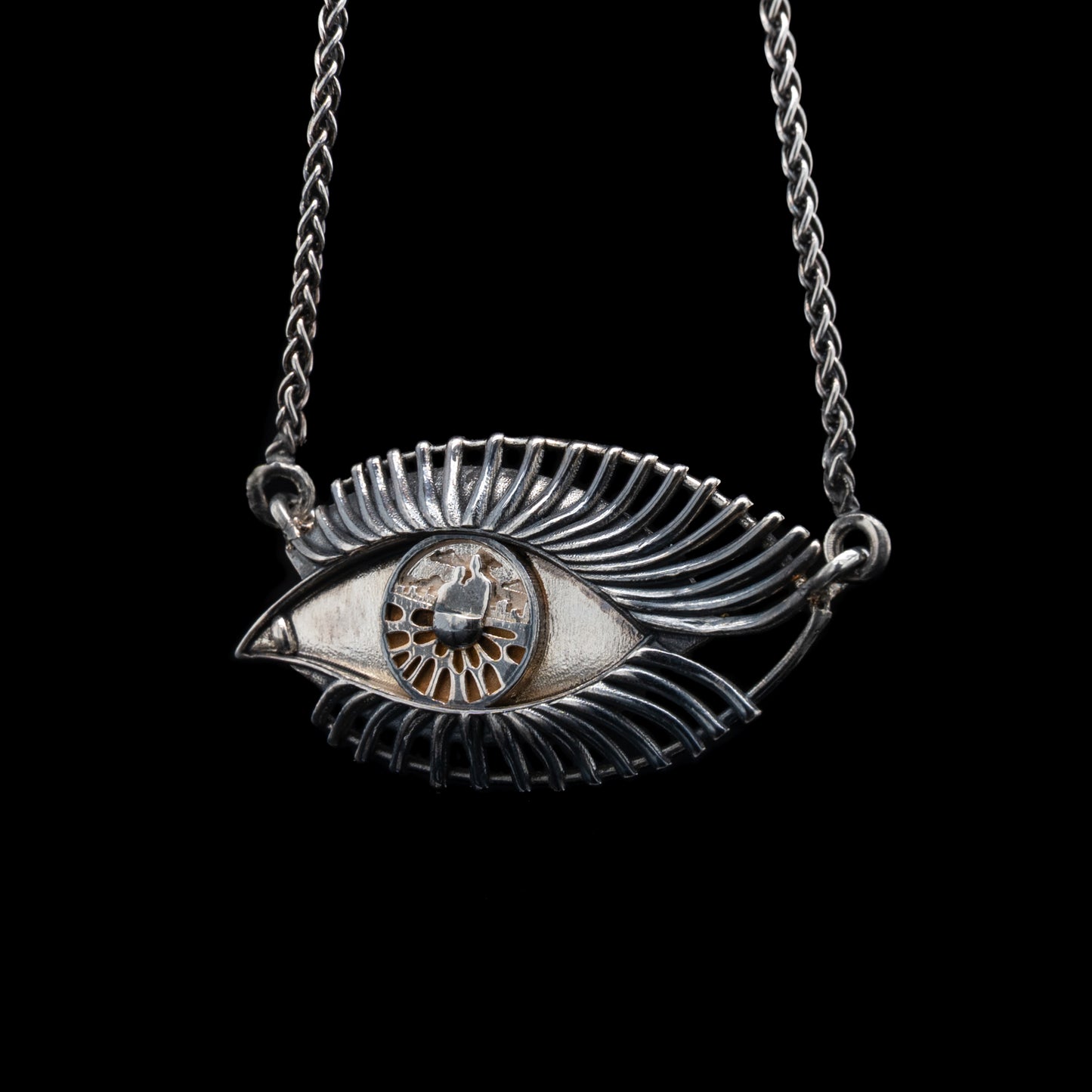 Silver eye-shaped pendant necklace on a black background