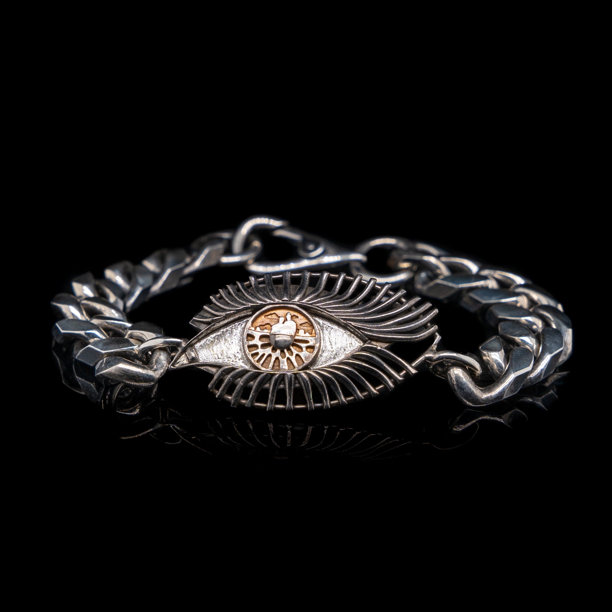 Silver bracelet with eye design on a black background