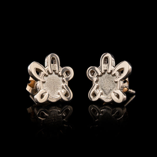 Pair of silver earrings with intricate designs on a black background