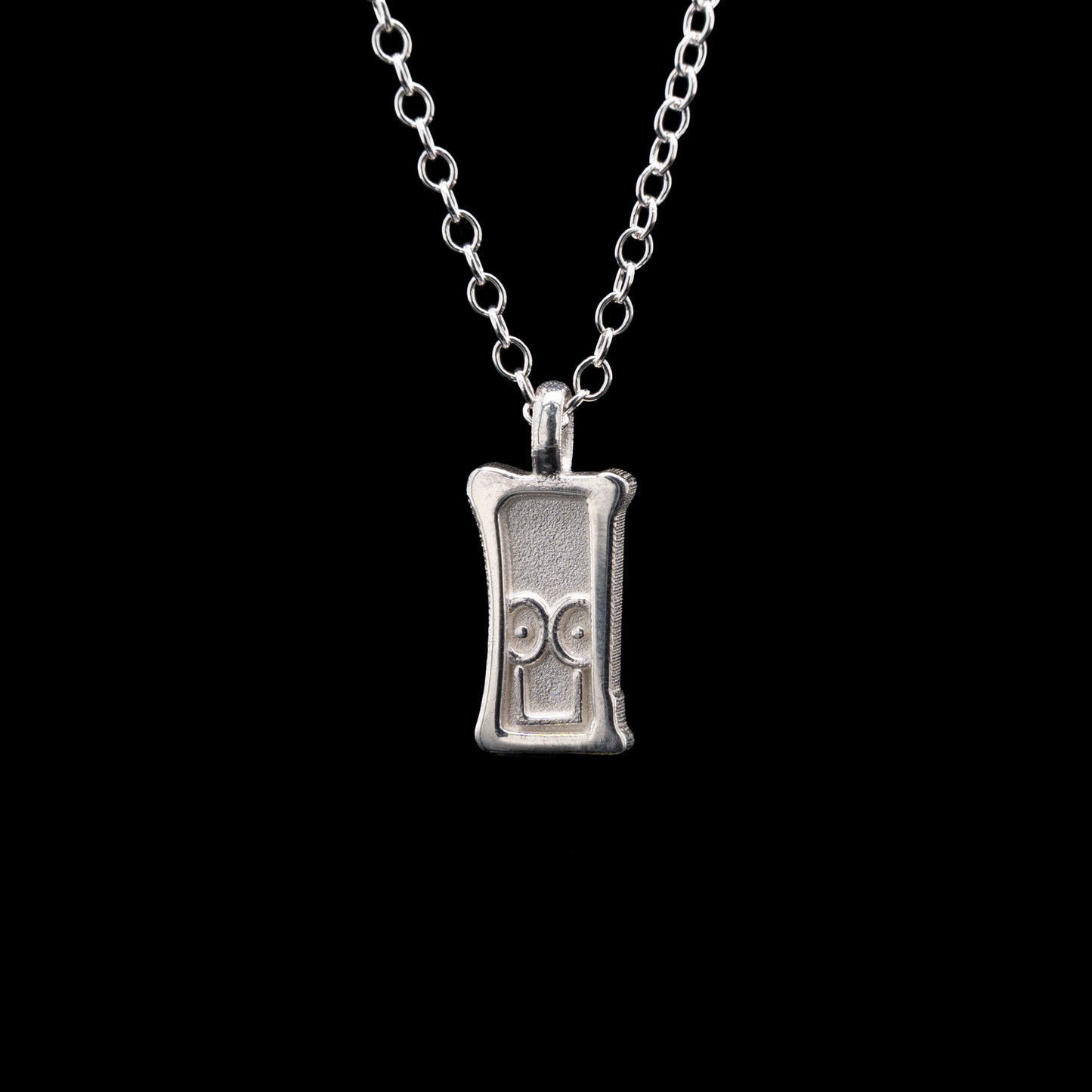 Everyman sterling silver smile head charm pendant necklace on a black background.