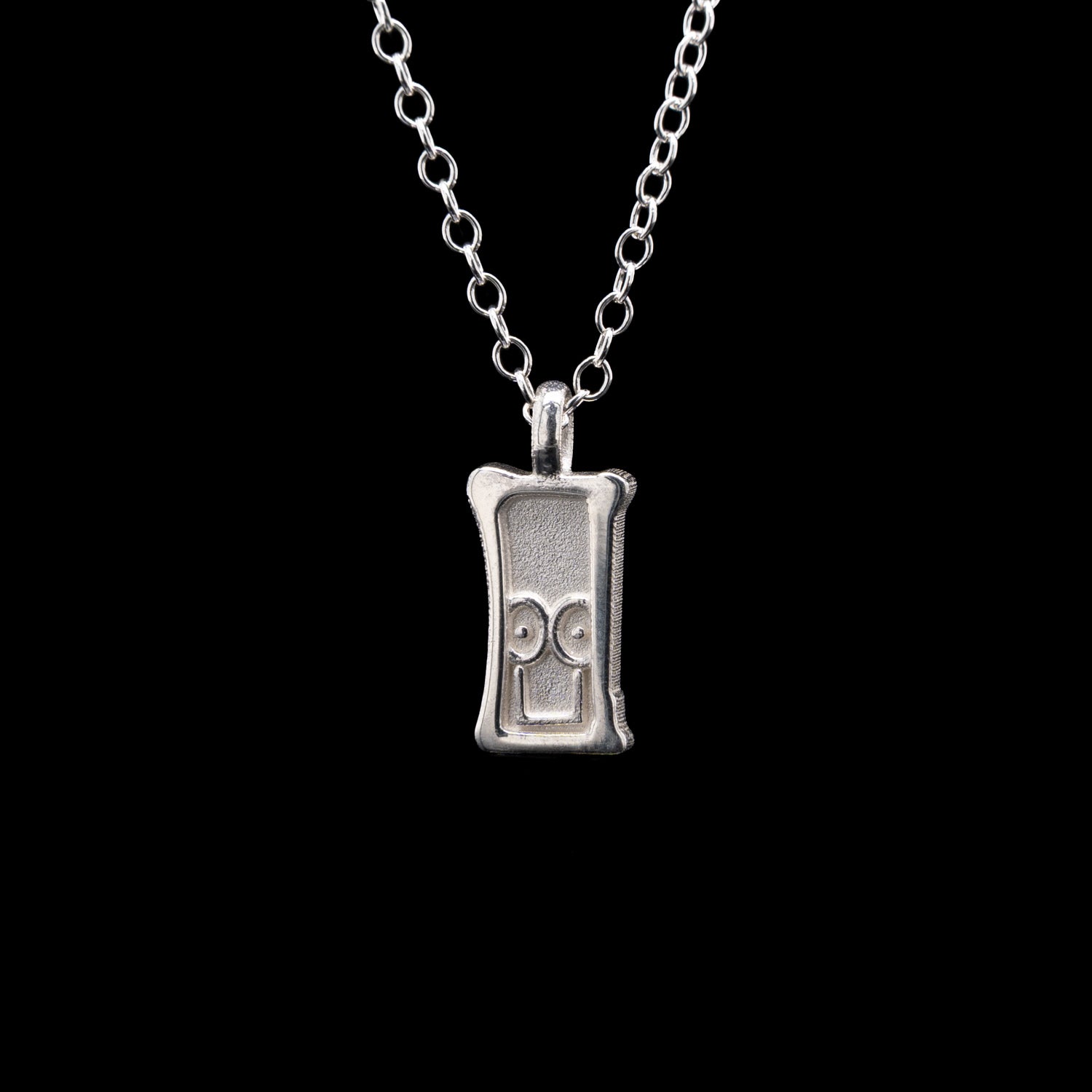 Everyman sterling silver smile head charm pendant necklace on a black background.