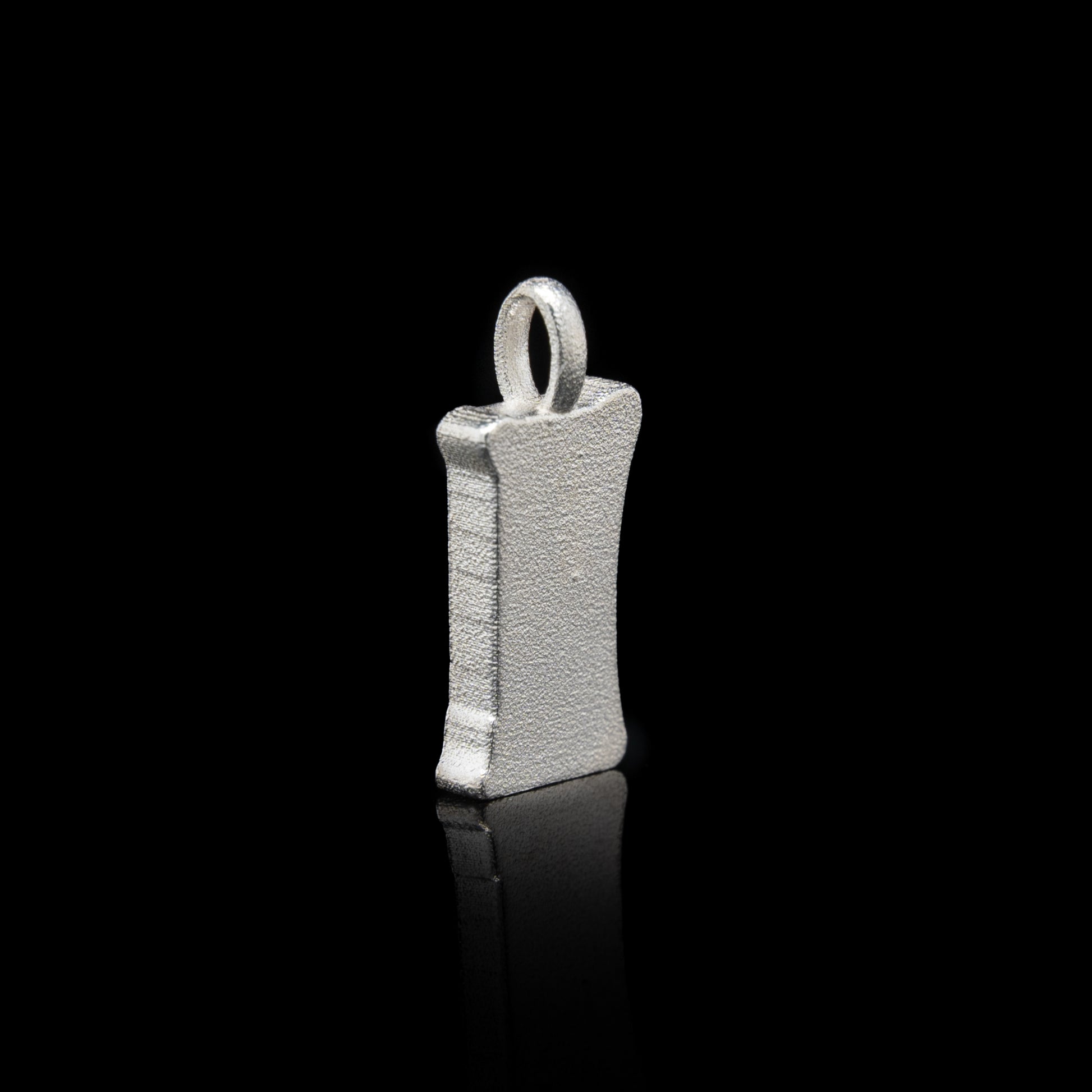 Back of everyman sterling silver smile head charm pendant with a unique design on a black background