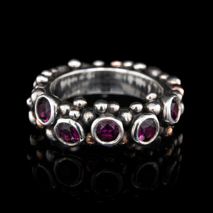 Silver ring with grape garnets gemstones on a black background.