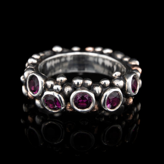 Silver ring with grape garnets gemstones on a black background.
