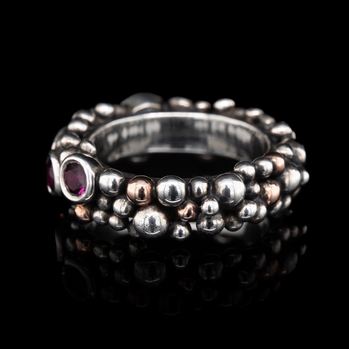 side view of bubble Silver ring with grape garnets gemstones on a black background