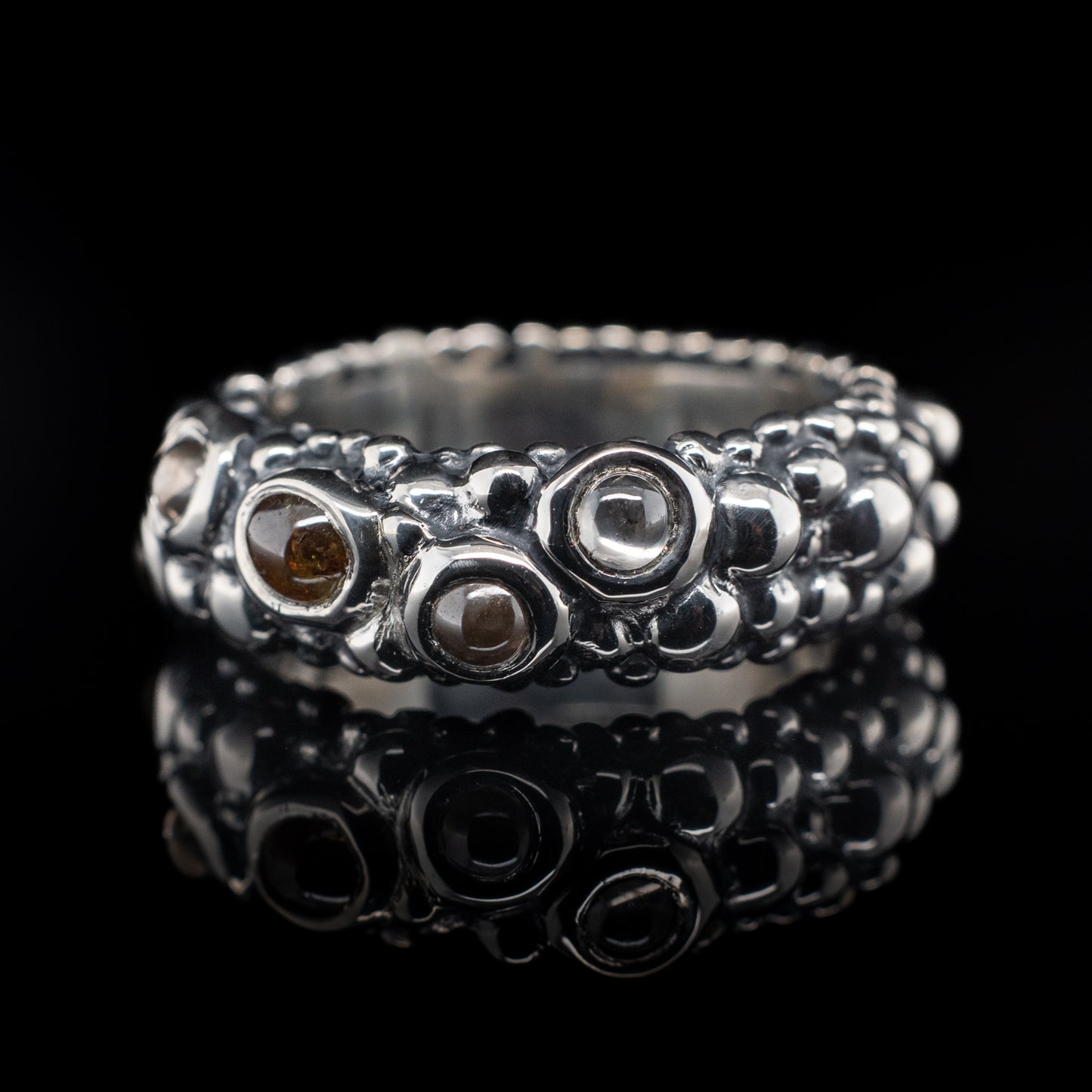 A sterling silver bubble ring with a series of salt and pepper cabochons diamonds set within it.