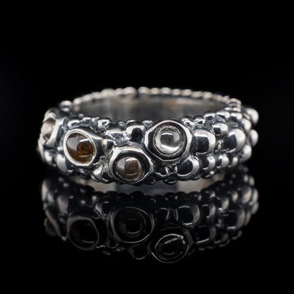 A sterling silver bubble ring with a series of salt and pepper cabochons diamonds set within it.